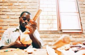 A man carves a piece of wood